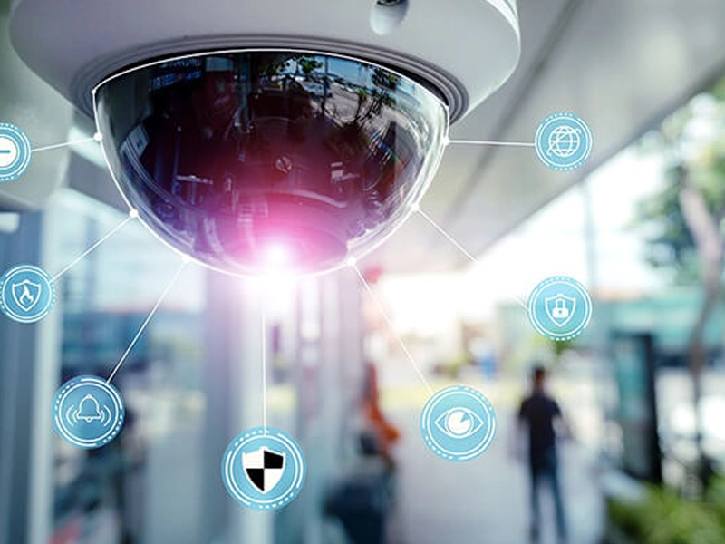 A modern business security and IT dashboard showing cameras, network devices, cybersecurity alerts, and connected systems.
